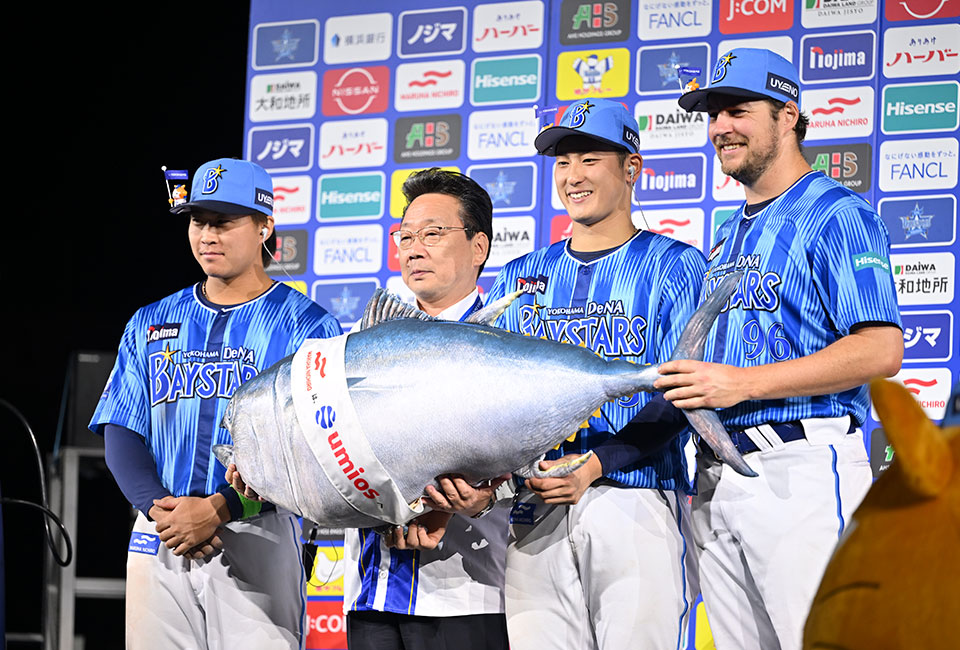 ヒーロー賞「完全養殖クロマグロ(１本分)」の贈呈式、写真左から、石上 泰輝選手、半澤取締役特任顧問、松尾 汐恩選手、バウアー選手（©YDB）